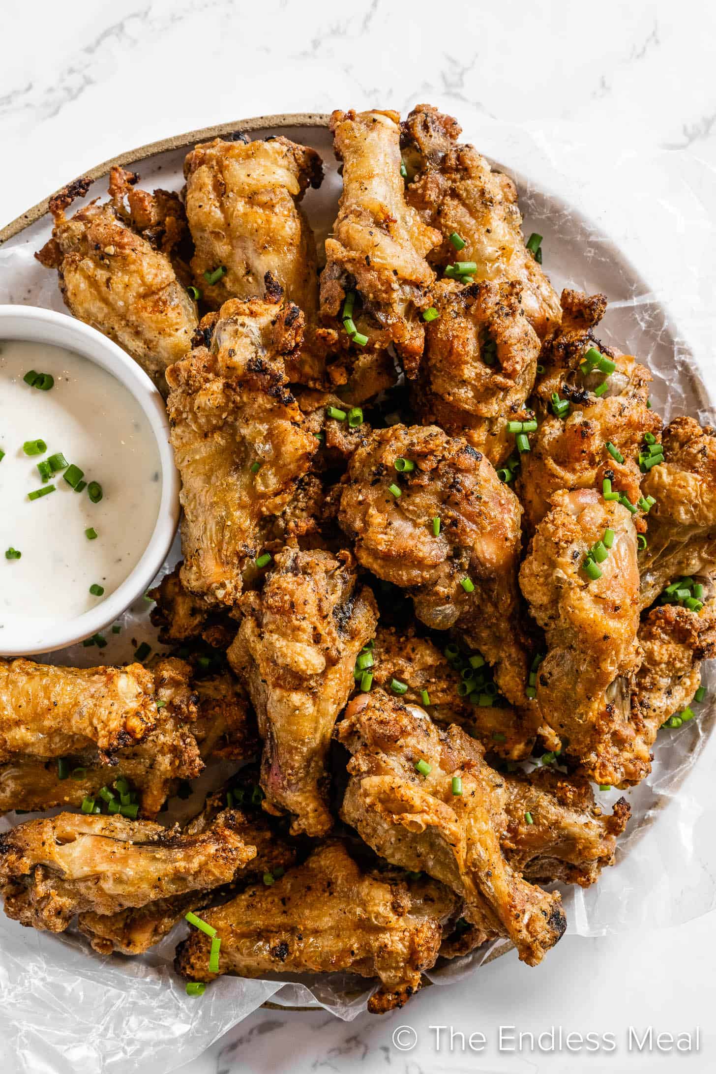 Salt and Pepper Chicken Wings on a serving plate with dip