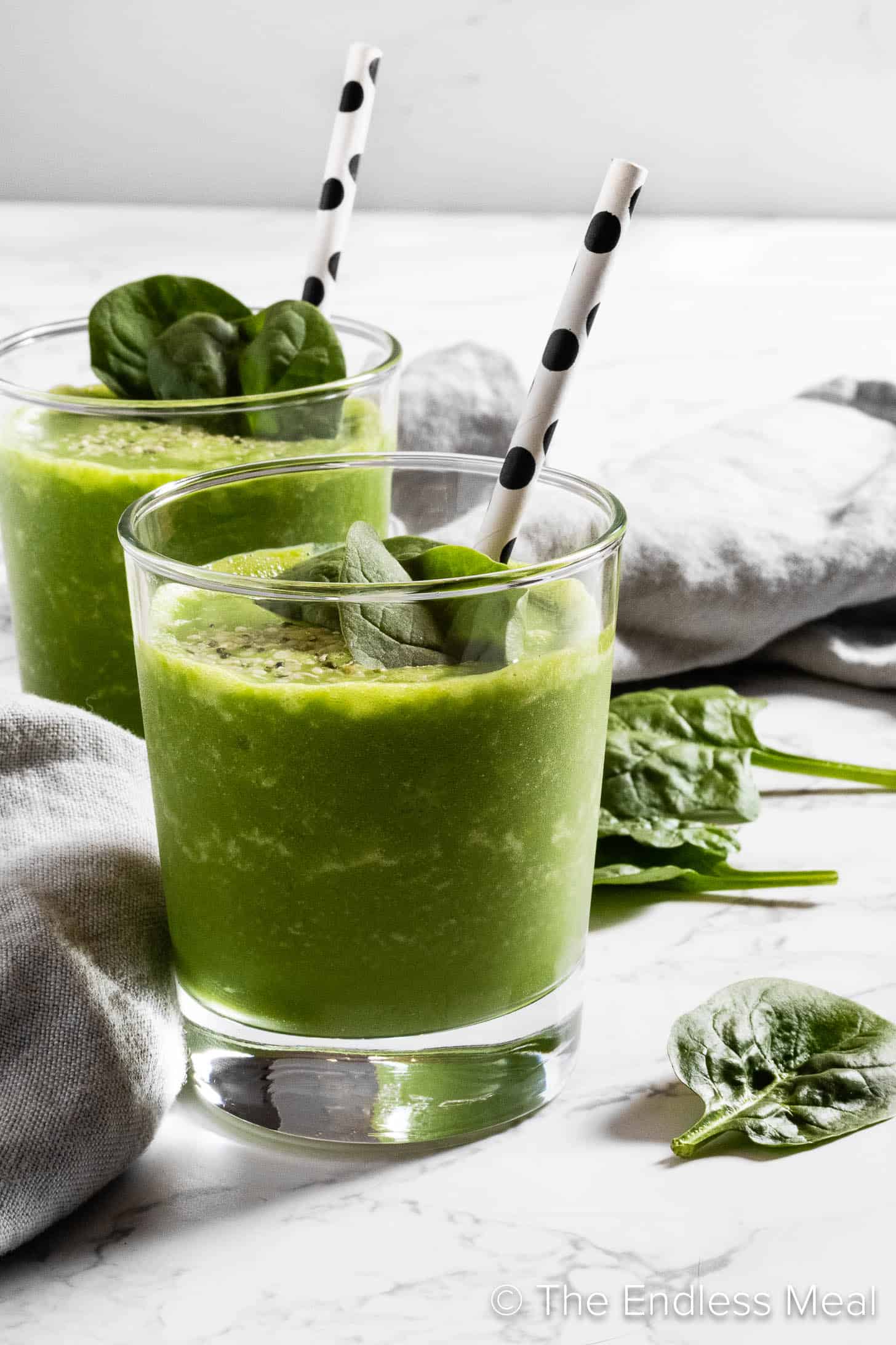 A glass of Spinach Smoothie with a straw