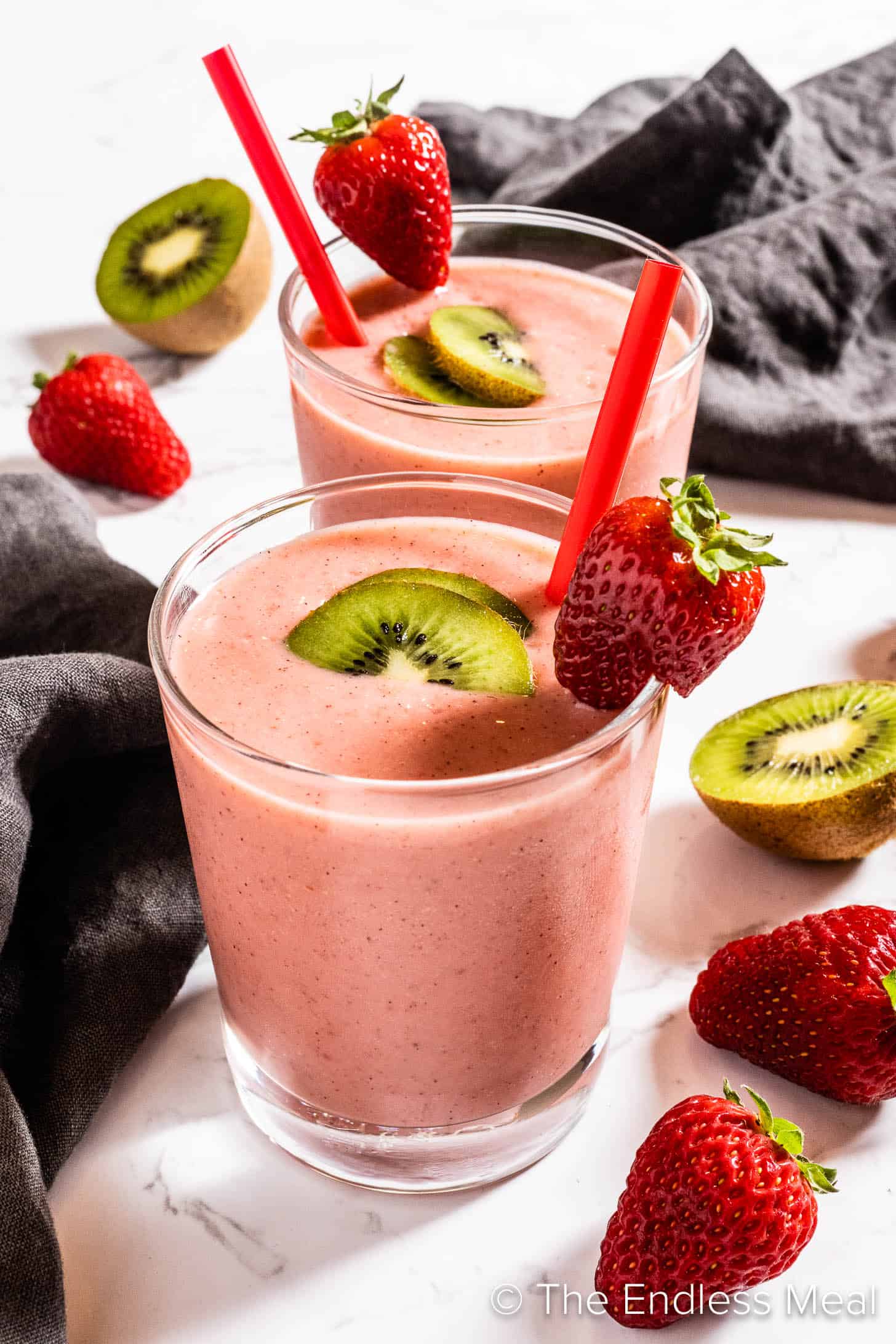 Strawberry Kiwi Smoothie in a glass with a red straw