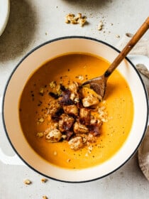 Sweet Potato Bisque in a pot topped with cinnamon toast croutons