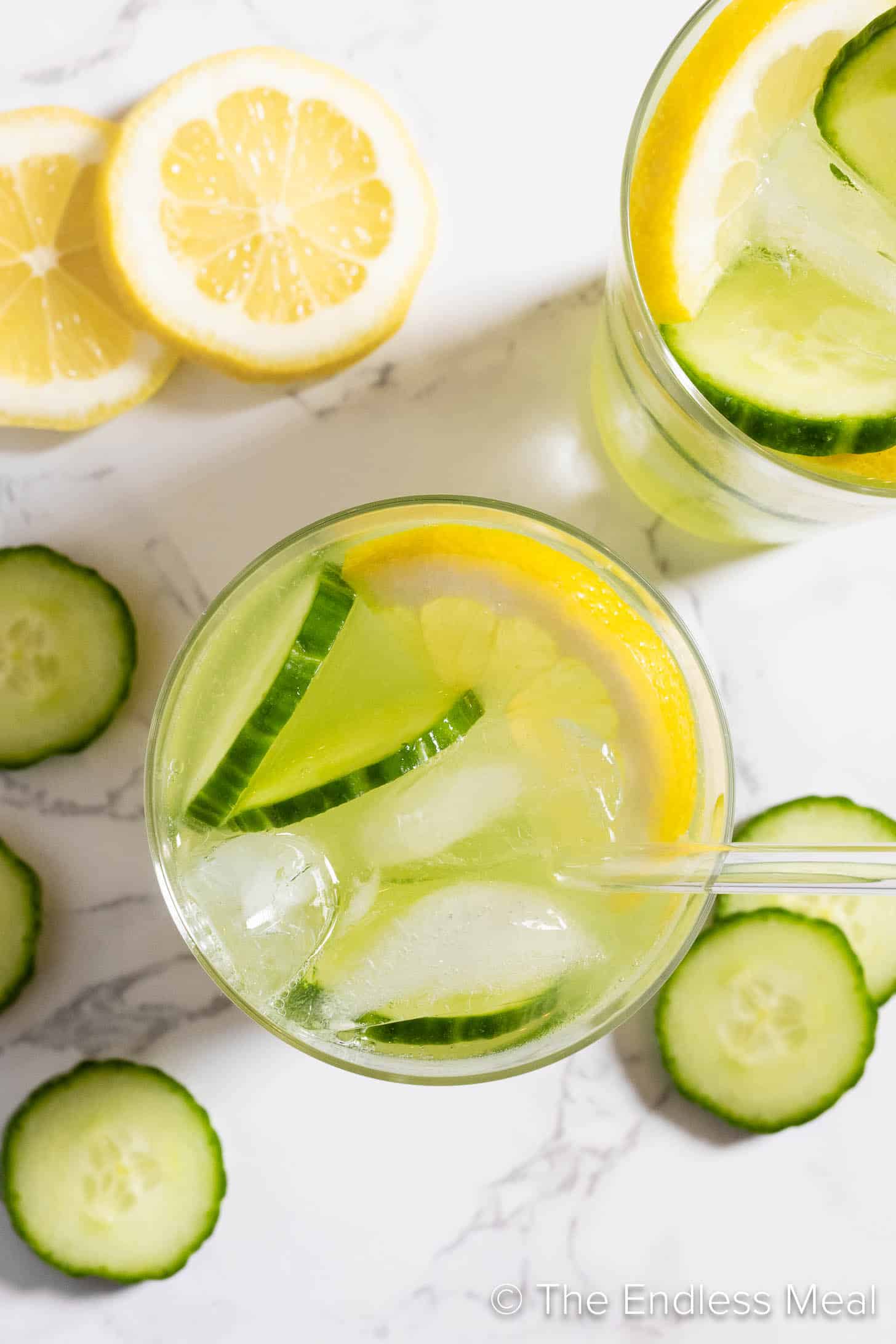 Looking down on glasses of lemonade with cucumbers.