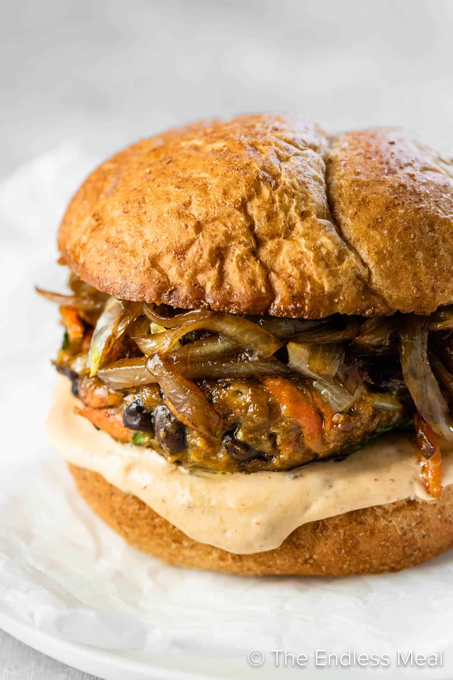 A homemade black bean veggie burger with onions and chipotle mayo