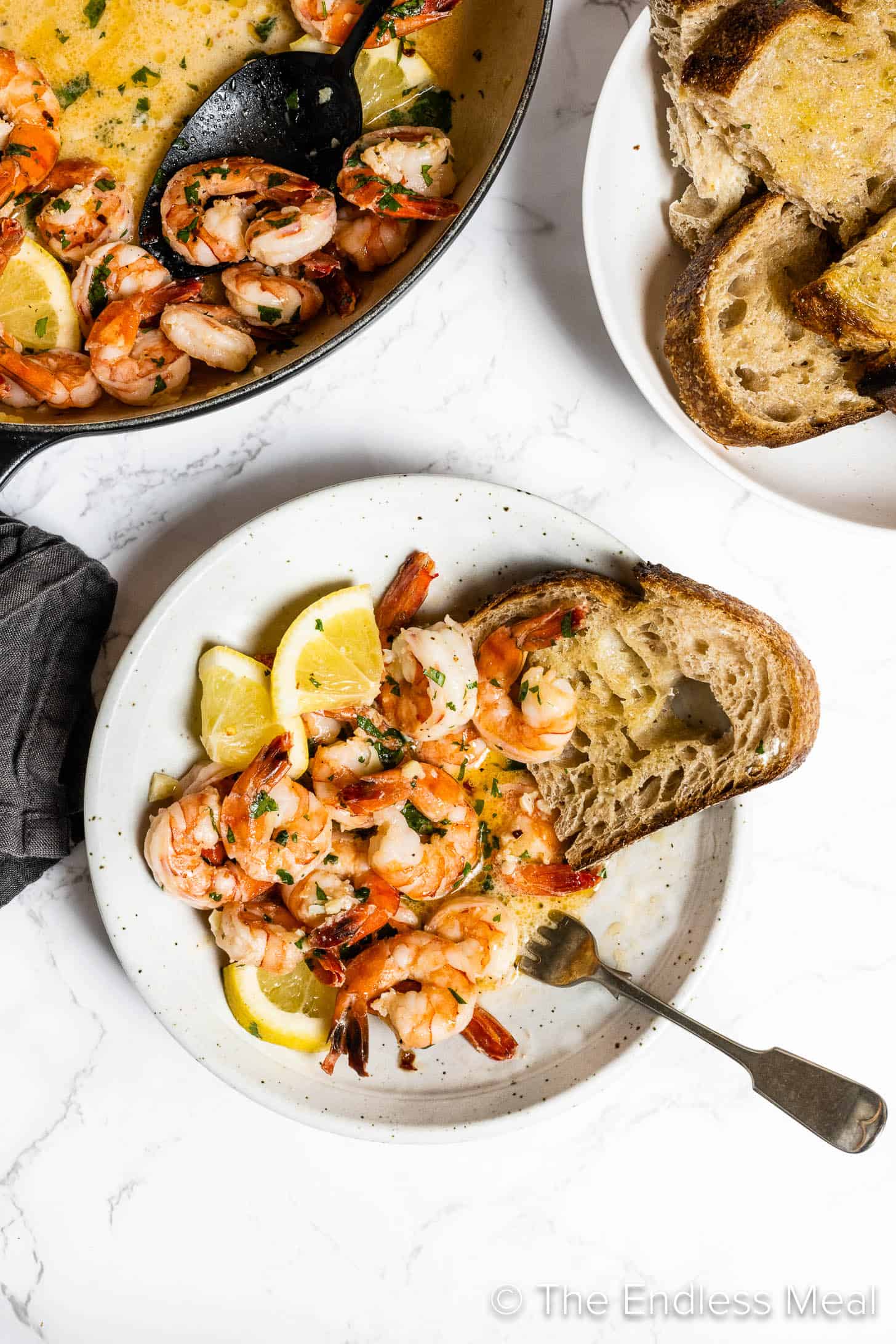A dinner table with Lemon Garlic Butter Shrimp and bread
