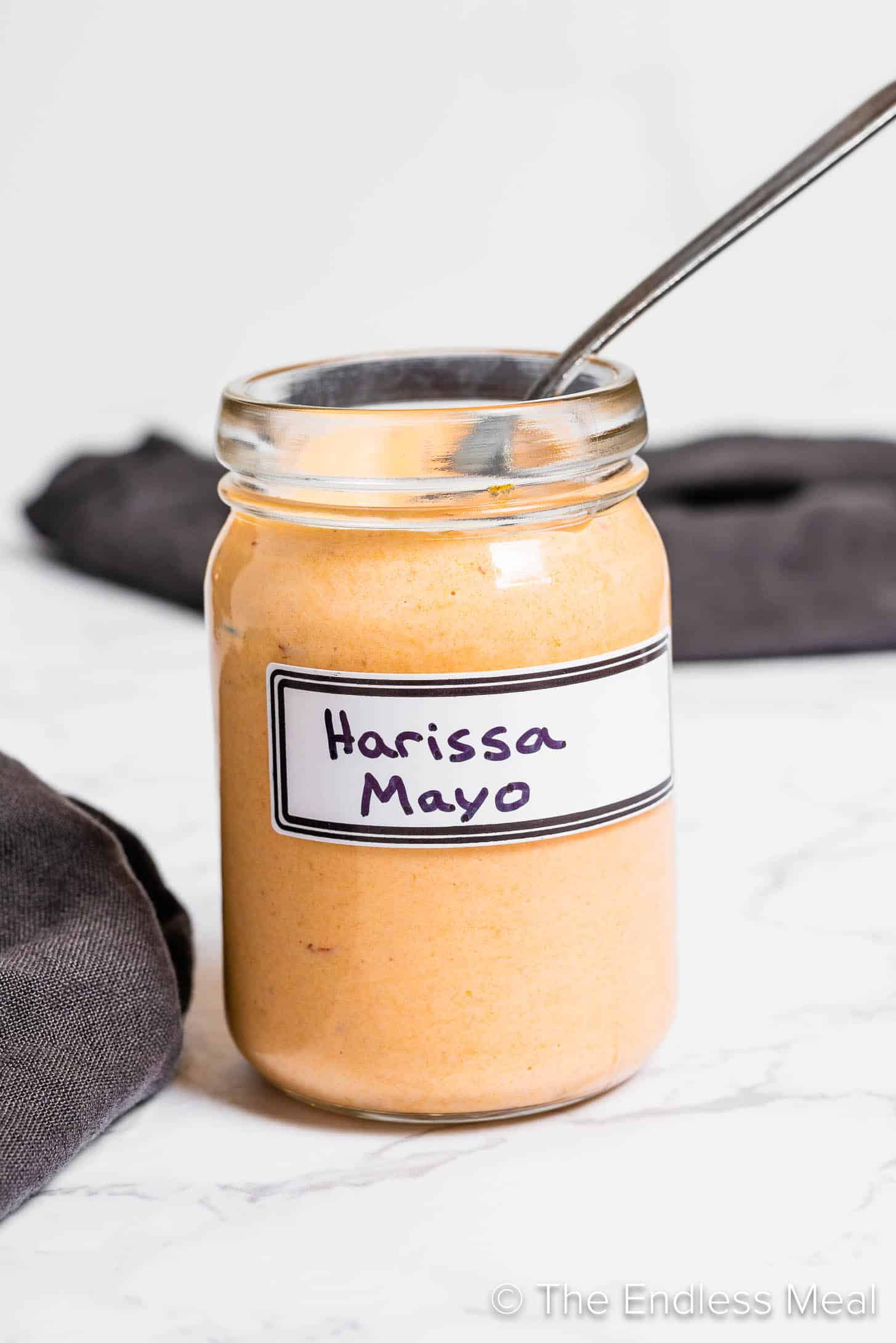 Harissa Mayo in a glass jar with a spoon