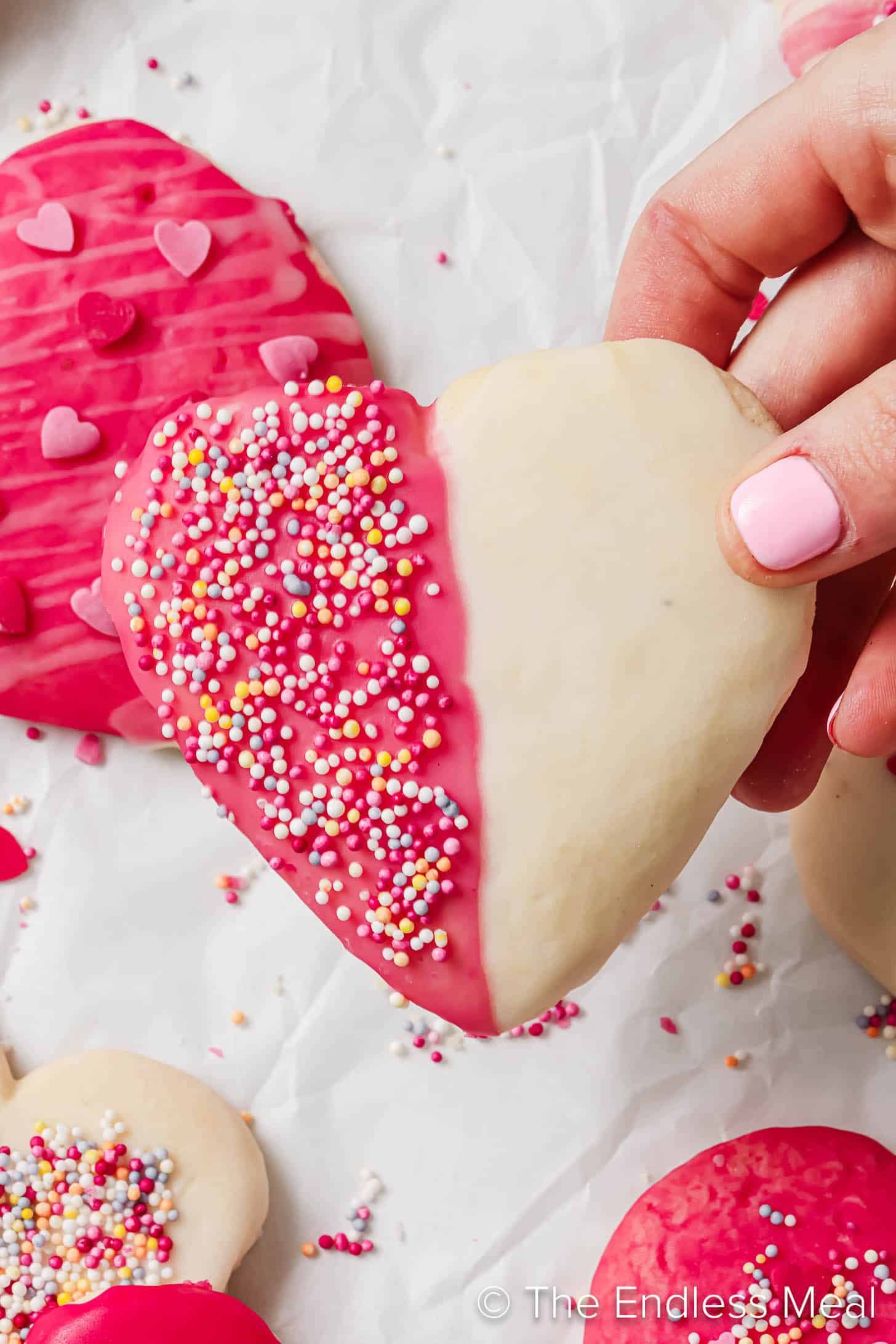 A hand holding Heart Shaped Sugar Cookies