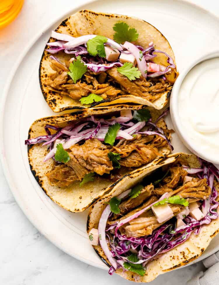 Three Pulled Pork Tacos on a dinner plate
