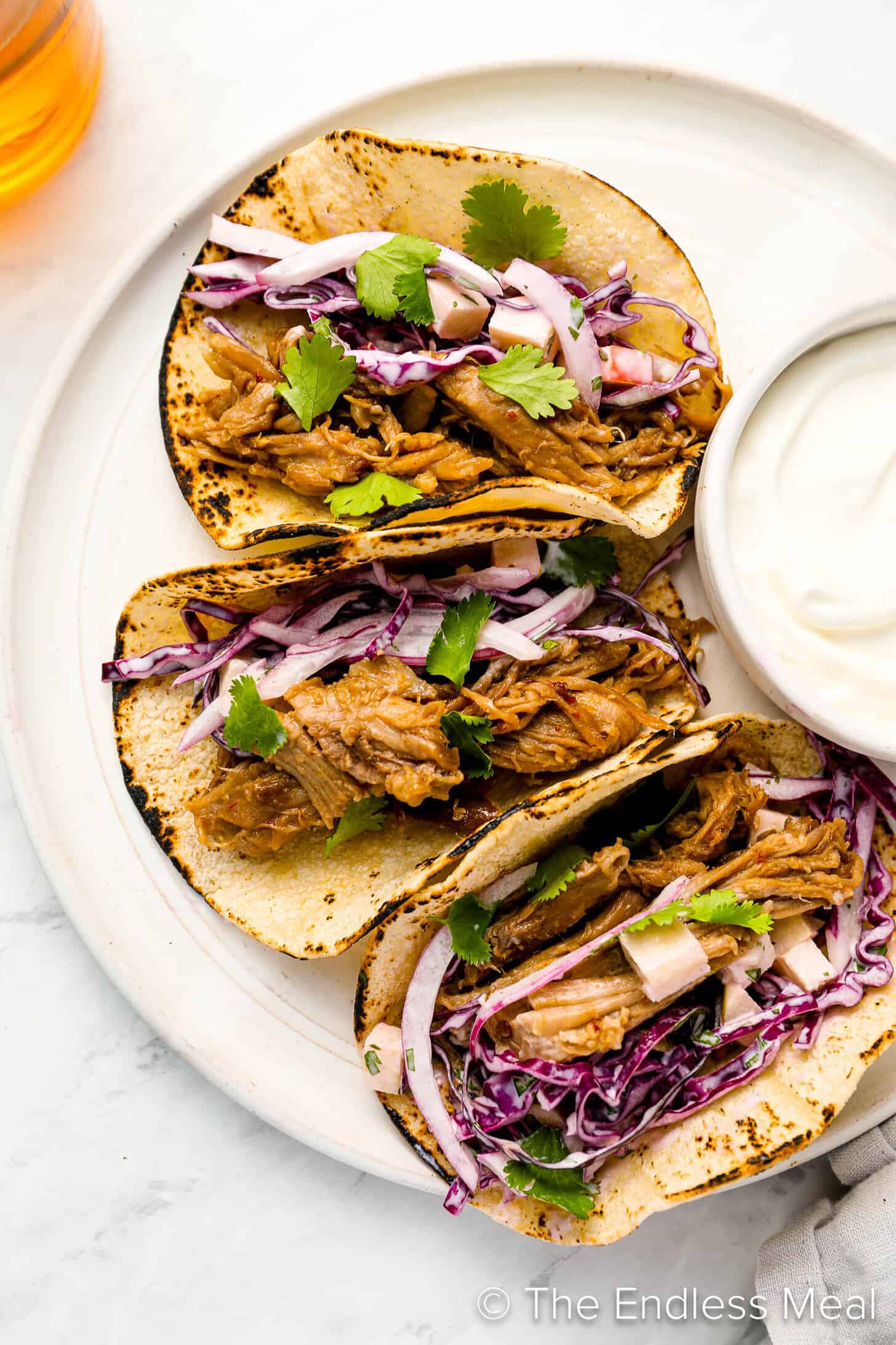 Three Pulled Pork Tacos on a dinner plate