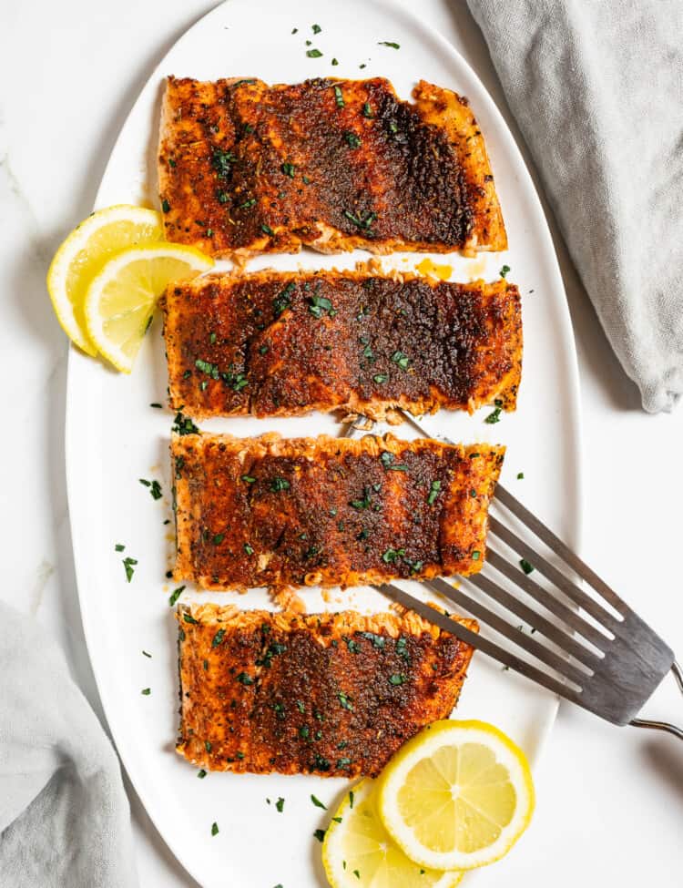 Paprika Salmon on a serving tray with lemons.