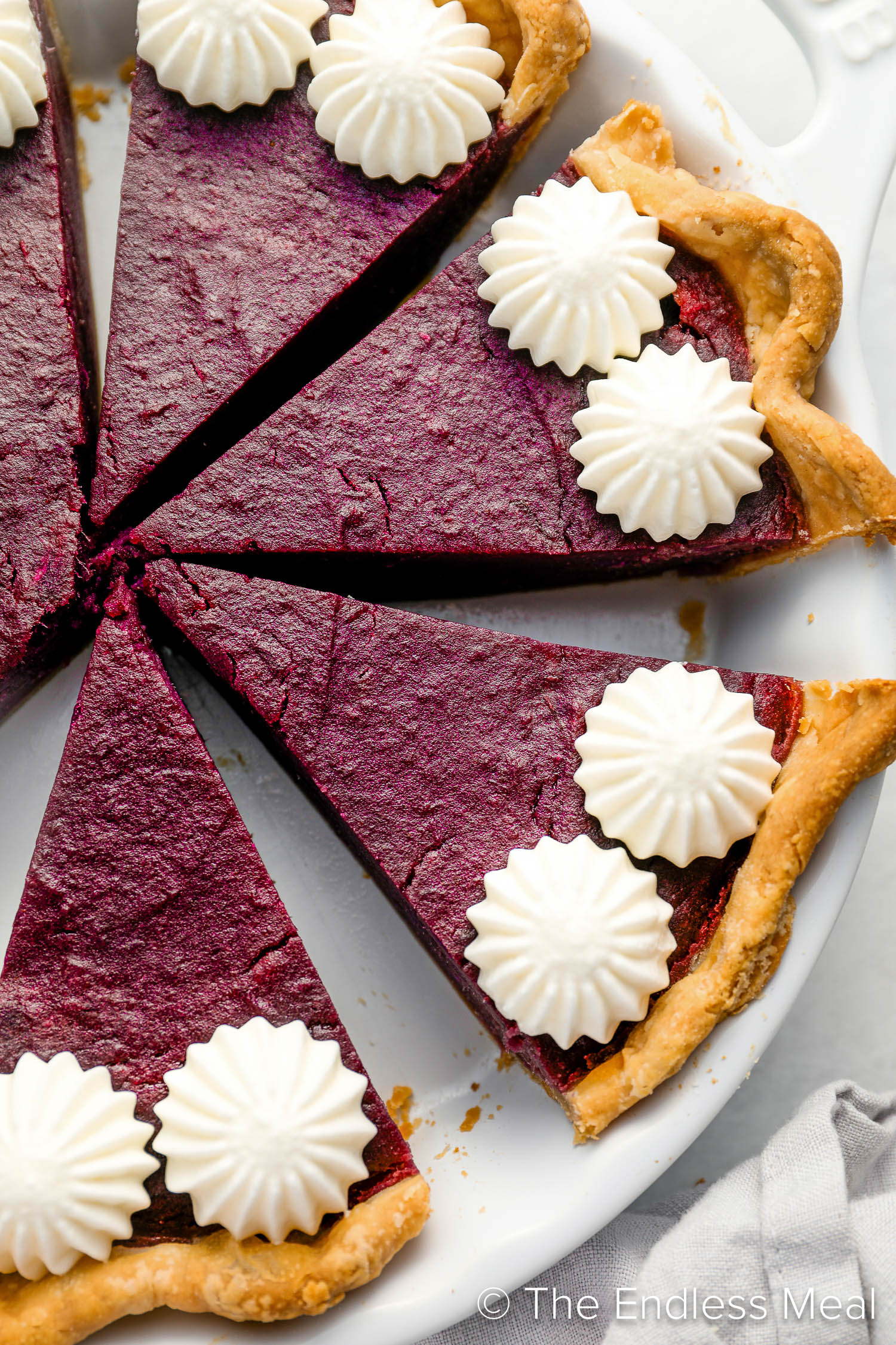 A close up of slices of Purple Sweet Potato Pie with whipped cream