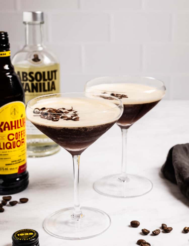 Two Chocolate Espresso Martinis next to a bottle of vodka and a bottle of Kahlua