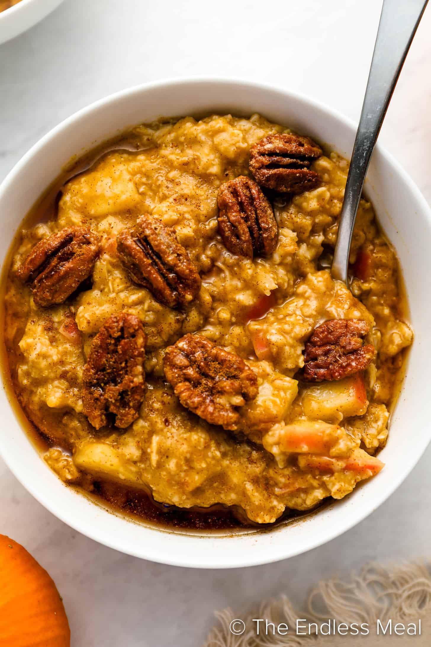 Pumpkin Oatmeal topped with candied pecans in a bowl.
