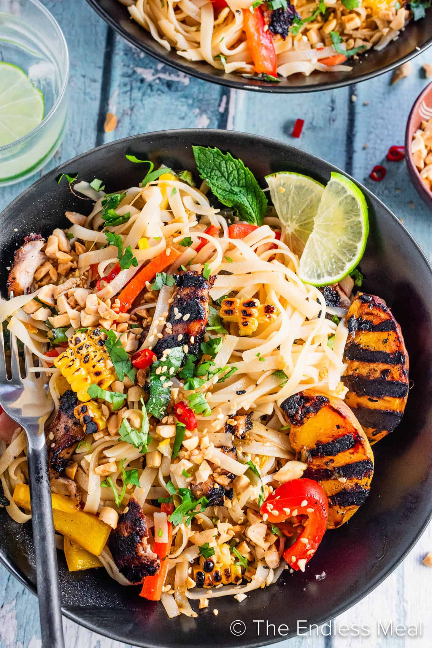 A bowl of Grilled Chicken Pad Thai with peaches
