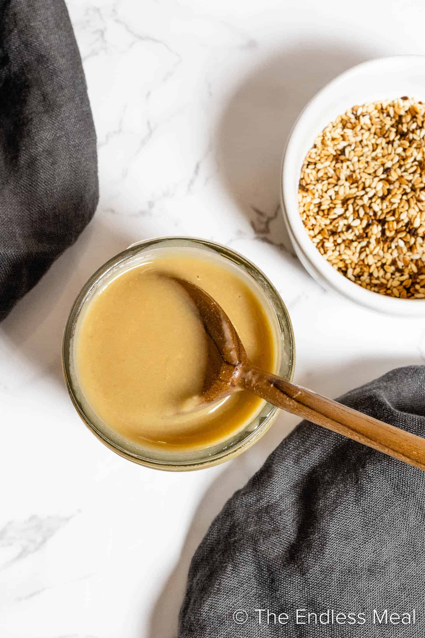 tahini maple dressing.in a jar with a spoon