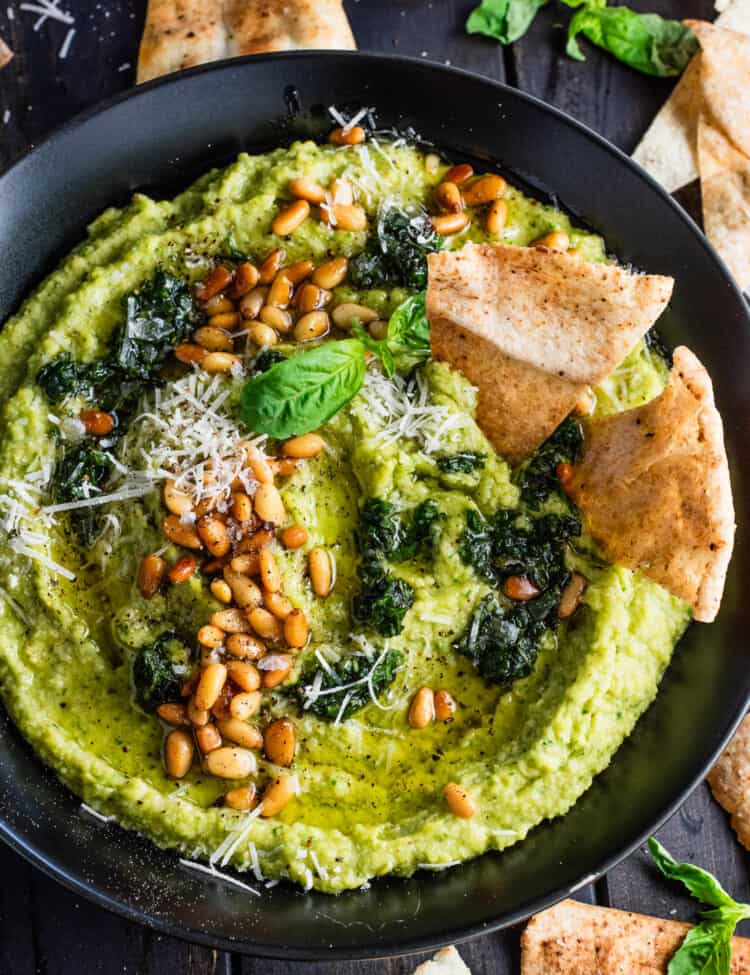 Pesto Hummus with homemade pita chips in a serving bowl