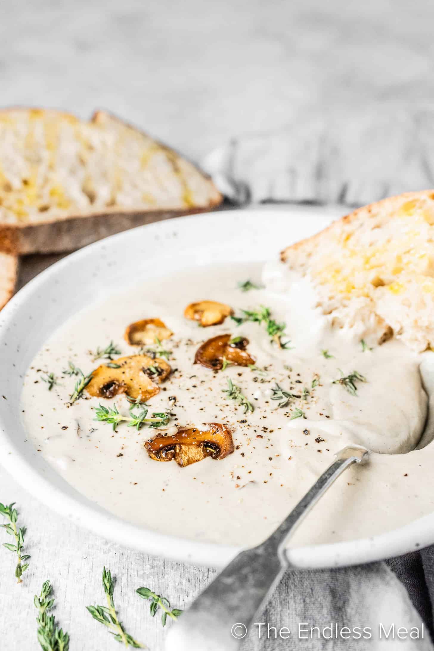 Cashew Soup in a bowl with mushrooms and bread