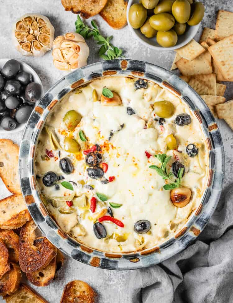 Cheesy Baked Olive Dip on the table with crackers