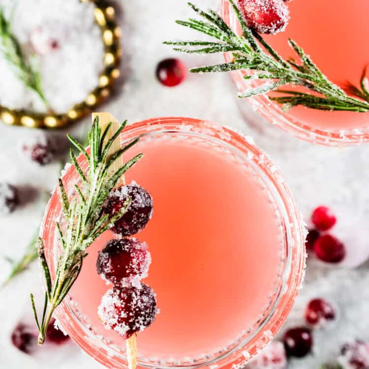 A Christmas Cranberry Margarita garnished with rosemary and sugared cranberries