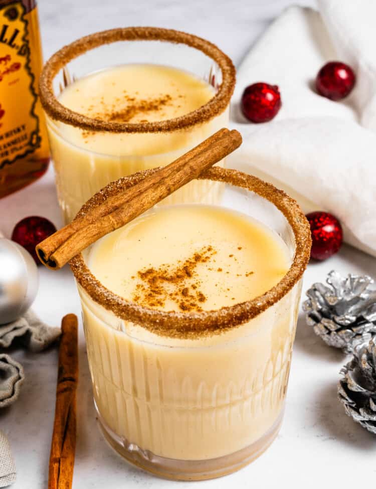 Two glasses of Fireball Eggnog next to Christmas decorations