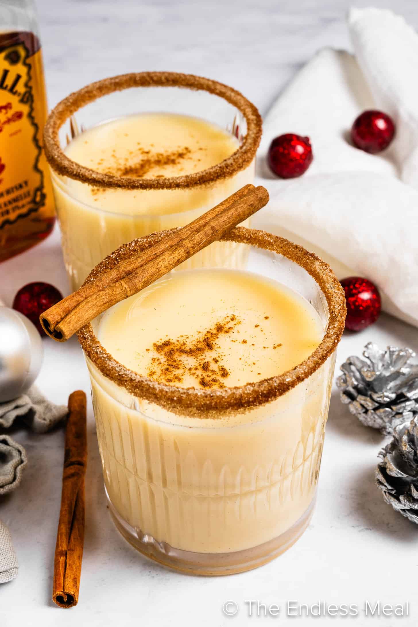 Two glasses of Fireball Eggnog next to Christmas decorations