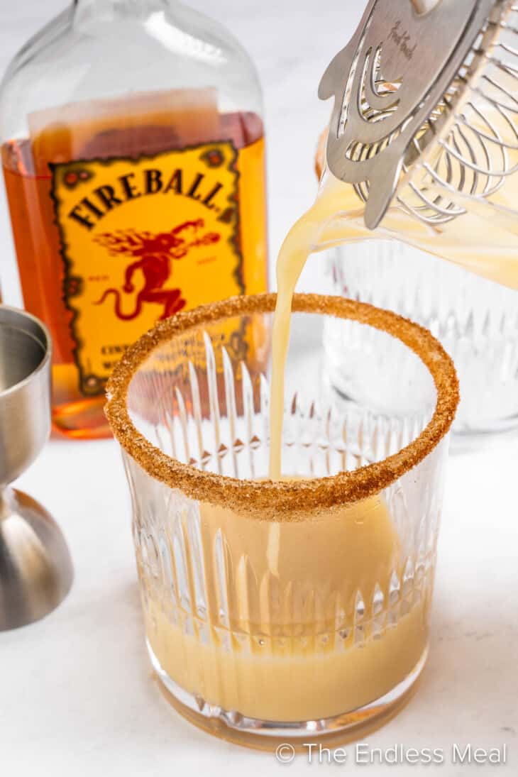 Pouring a Fireball Eggnog into a cocktail glass