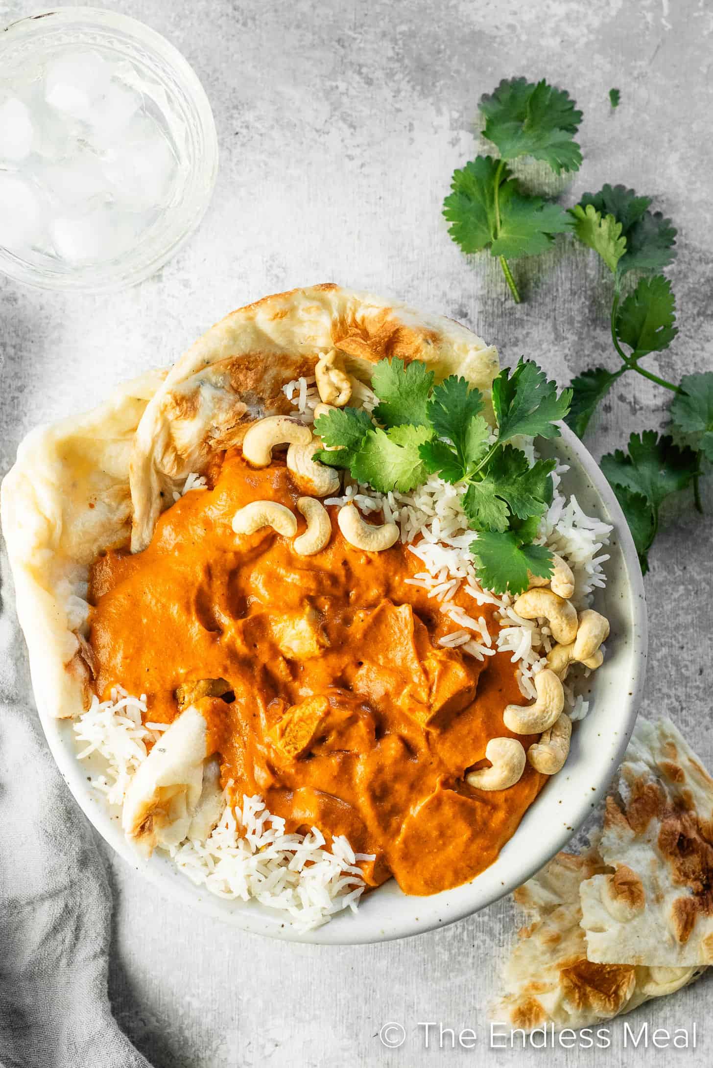 Cashew Butter Chicken in a dinner bowl with rice and naan