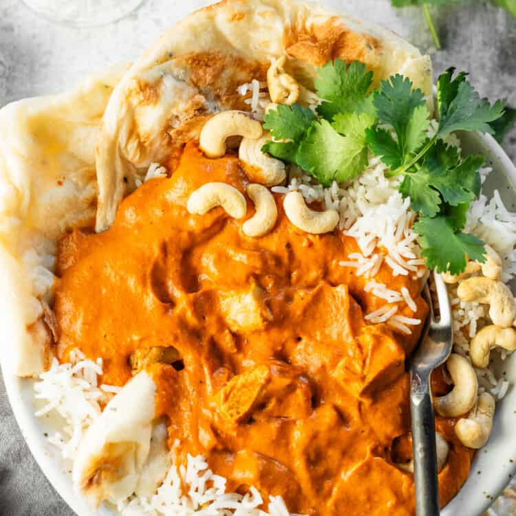 A close up of Cashew Butter Chicken in a bowl with rice