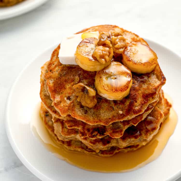 A stack of Banana Protein Pancakes with maple syrup