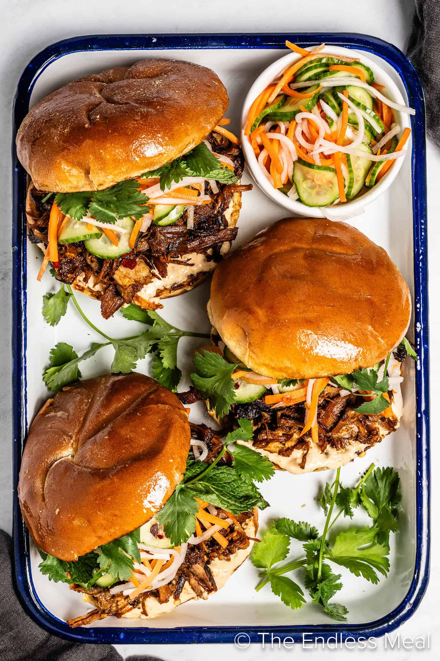 Looking down on three Korean Pulled Pork Sandwich on a serving tray