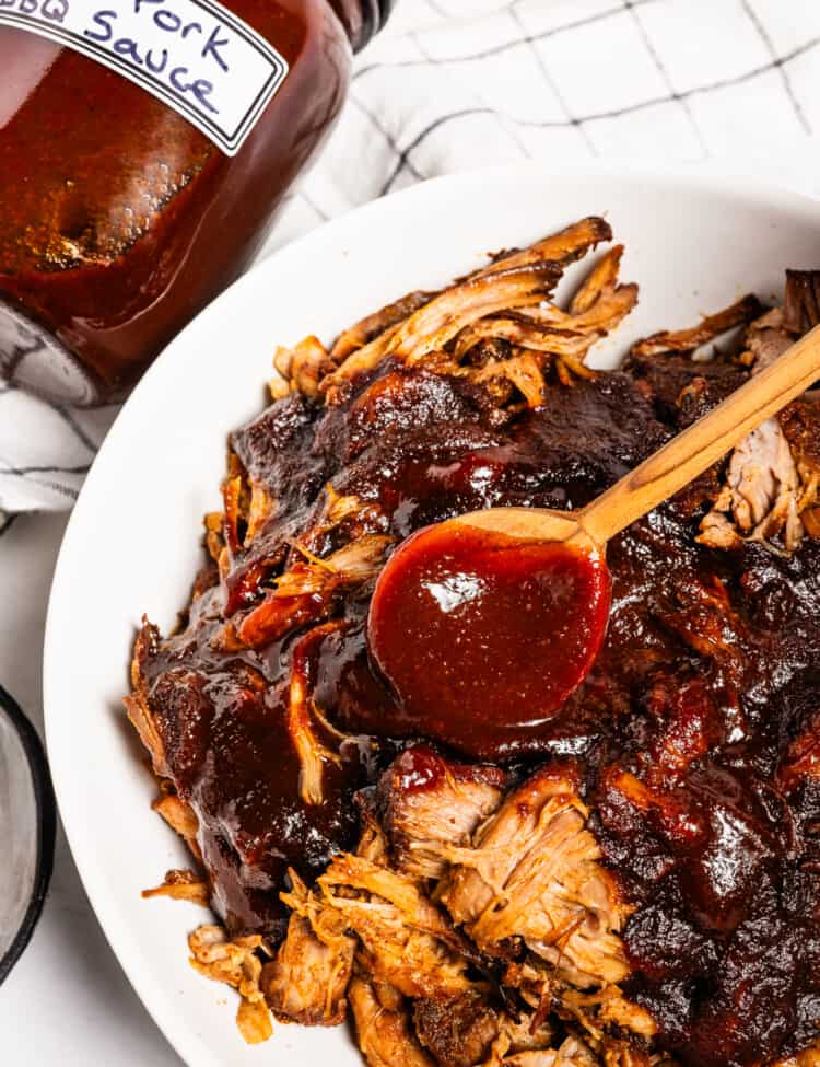 BBQ sauce being spooned over pulled pork
