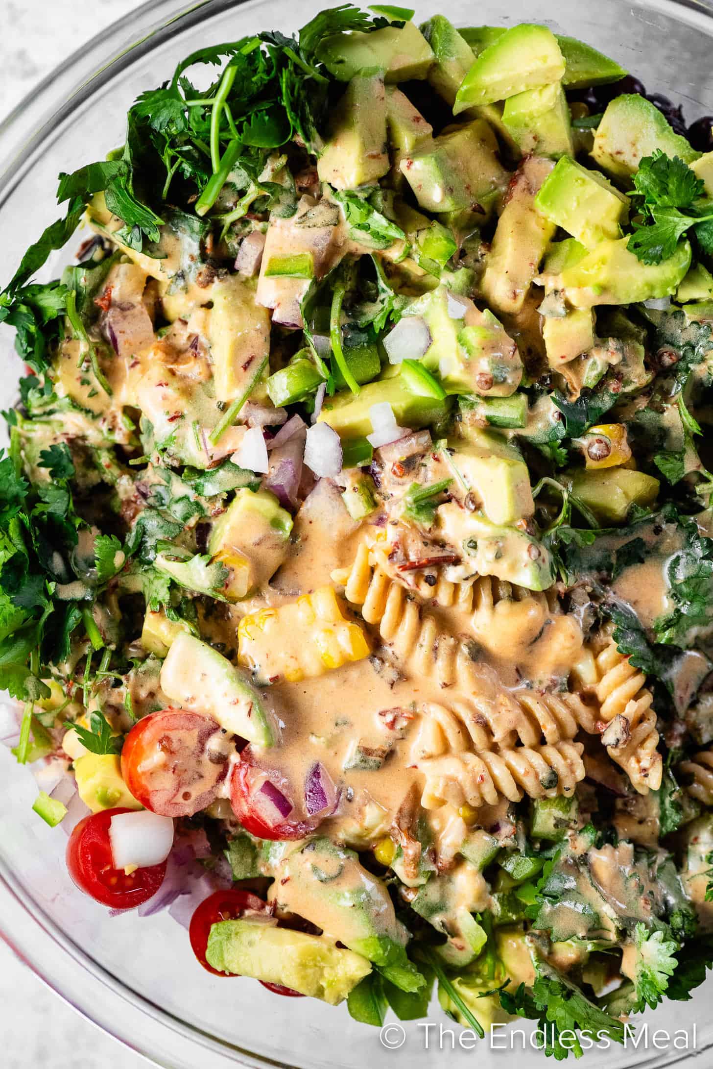 Chipotle dressing poured over Mexican Pasta Salad