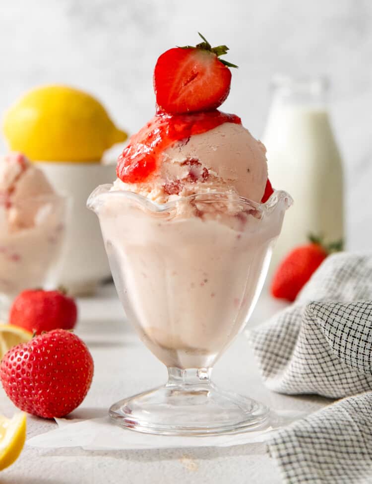 Strawberry Lemonade Ice Cream in an ice cream cup with a strawberry on top.