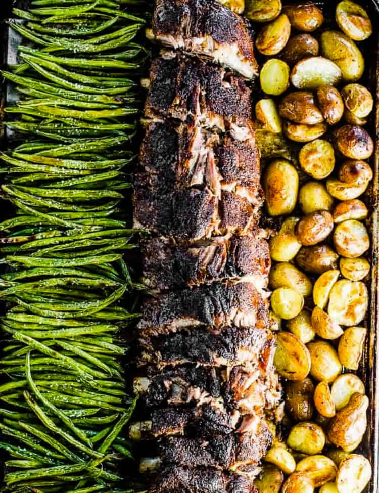 Baked ribs and potatoes with green beans on a sheet pan