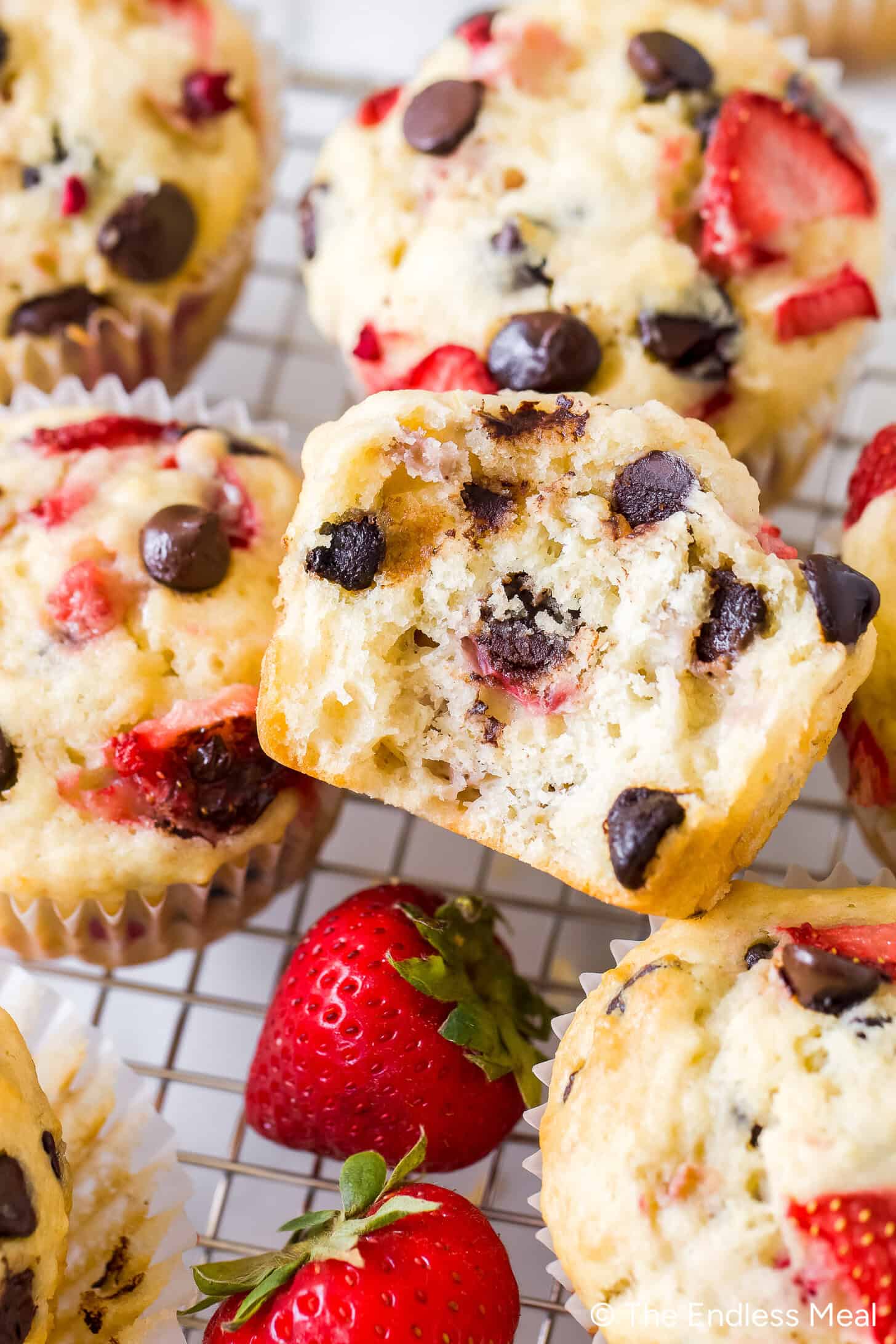 Strawberry rhubarb chocolate chip muffins on a cooling rack.