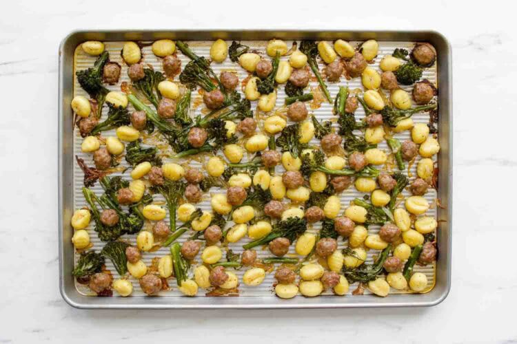 A Sheet Pan Gnocchi dinner featuring roasted gnocchi, sausage pieces, and broccolini spread out in a single layer for easy baking and cleanup.