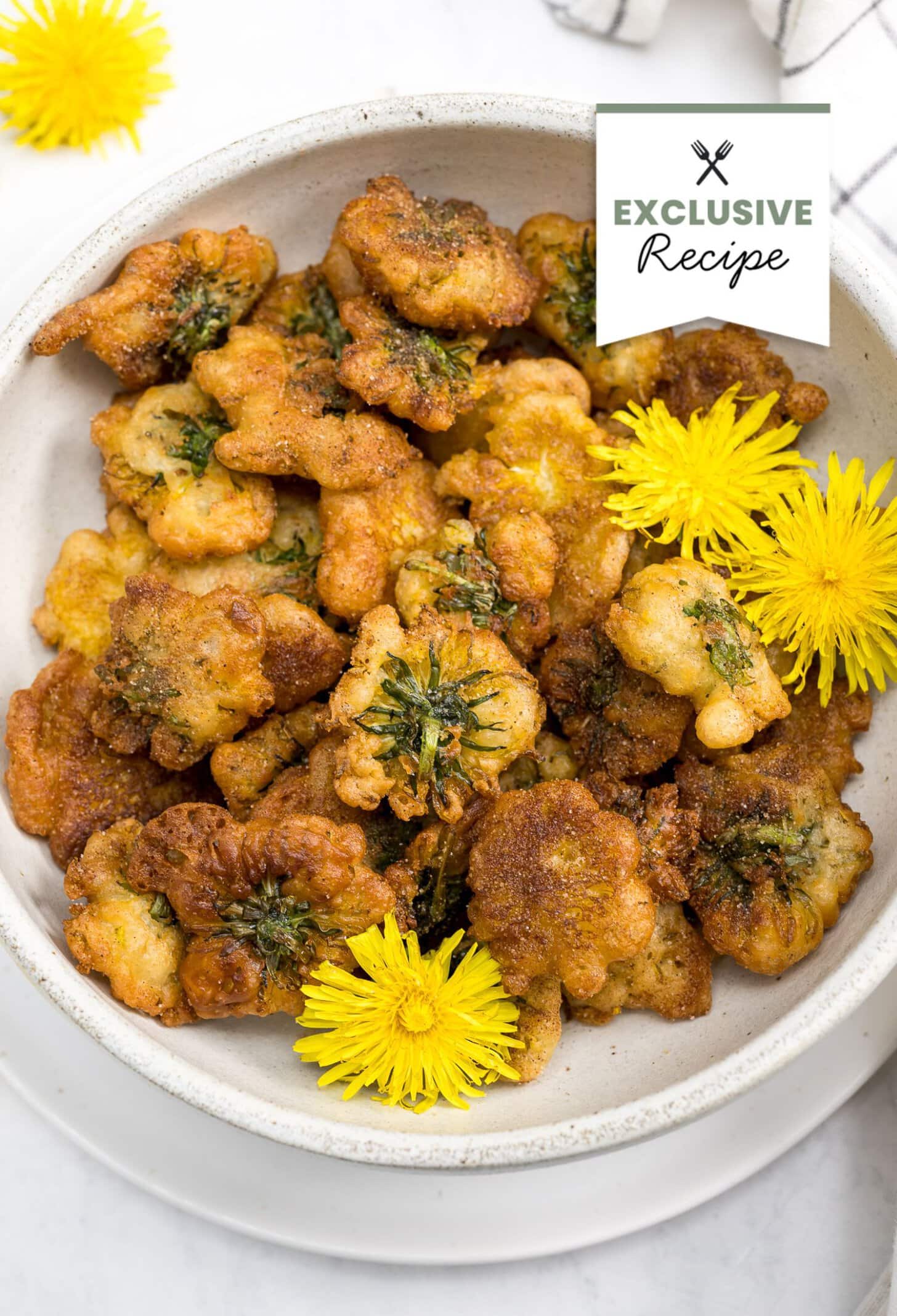 A bowl of fried dandelion fritters, reminiscent of Dandelion Donuts, garnished with fresh yellow dandelion flowers and labeled Exclusive Recipe.